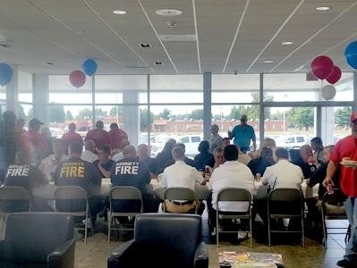 Team of Glen Sain GMC, Kennett seated on chairs, dressed in red, black, white, and blue outfits